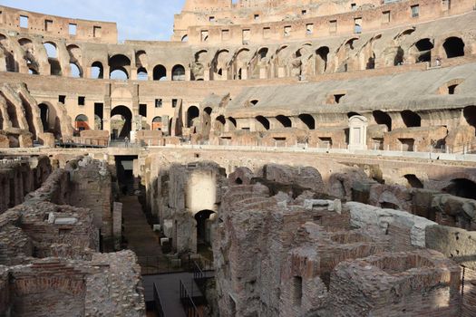 ROME, ITALY - February 05, 2022: Panoramic view around the Colosseum in city of Rome, Italy. Cold and gray sky in the background. Macro photography of the green parks with the old buildings.