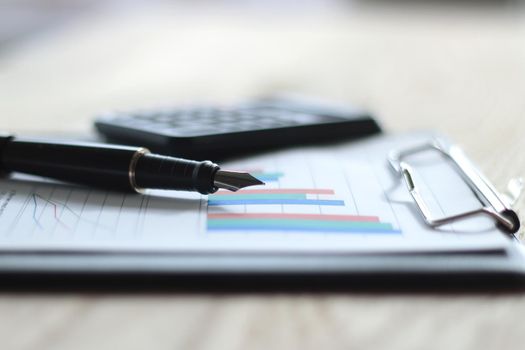 close up. gold-tipped pen and financial chart on the table.