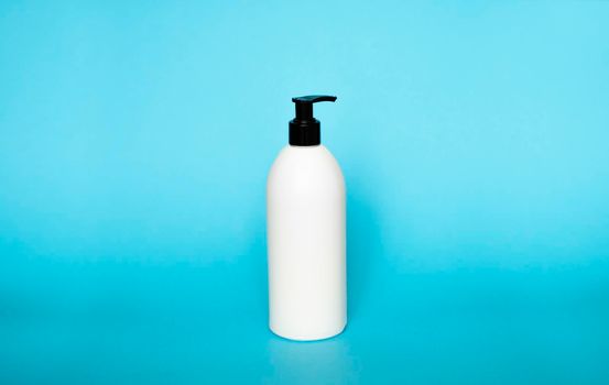 White plastic bottle with shampoo, conditioner or shower gel on a blue background. Mock up template for design