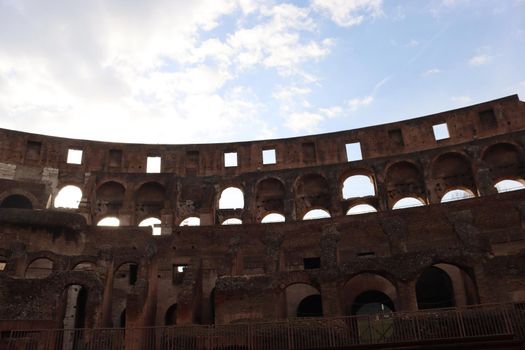 ROME, ITALY - February 05, 2022: Panoramic view around the Colosseum in city of Rome, Italy. Cold and gray sky in the background. Macro photography of the green parks with the old buildings.