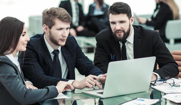 business team working on laptop with financial records in the modern office. the photo has a empty space for your text