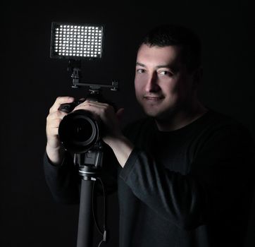 professional photographer with camera on tripod.isolated on black background.