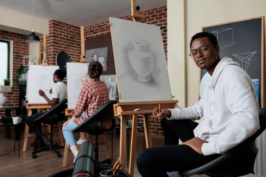 Portrait of painter student attending art class working at creative artwork drawing vase model using graphic pencil in creativity studio. Multiethnic team sketching draw. New years resolutions