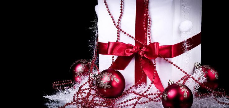 box with Christmas present and Christmas decorations on a black background. photo with copy space.