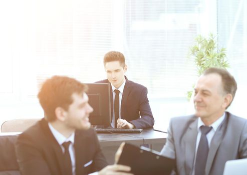 boss and employee discussing the document sitting at the Desk in the office.photo with copy space