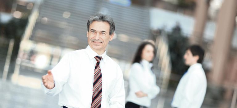 smiling businessman holding out his hand for greeting . the concept of cooperation .