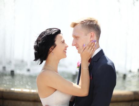 closeup portrait of bride and groom on the background of the fountain