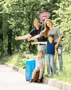 Cheerful friendly family with suitcases stops passing car