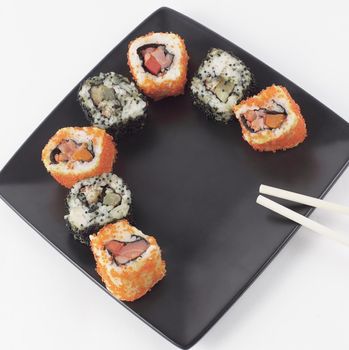 Sushi and rolls. the set is served on a black plate.isolated on a light background