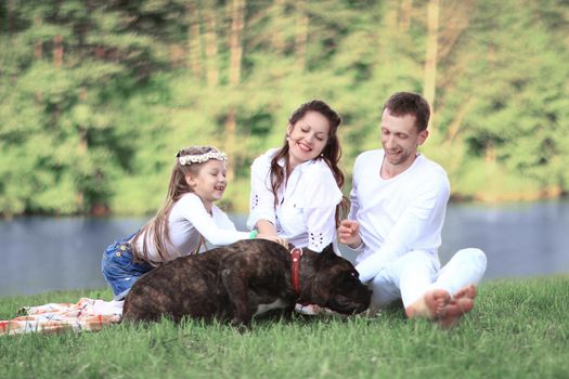 ,little daughter and their dog on a picnic by the river.the photo has a space for your text