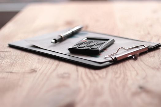 close up. blurred image of pen and calculator on desktop.