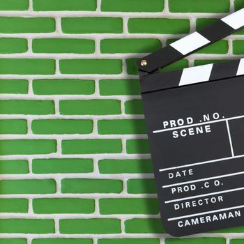 Movie production clapper board over brick wall background with copy space