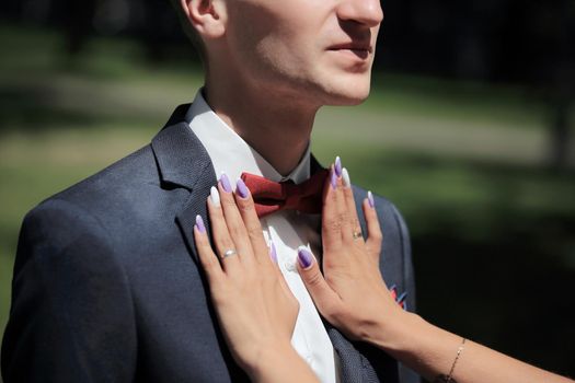 closeup.the bride helps the groom to correct bow-tie