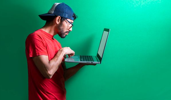 Guy in cap checking his laptop isolated, surprised man checking his laptop