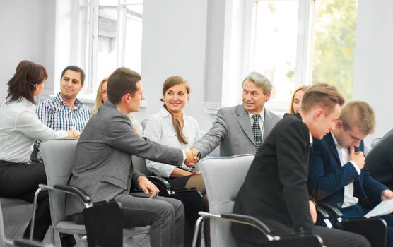 business partners shake hands in the conference room