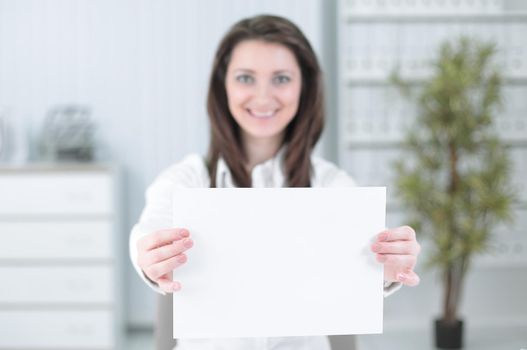 business woman showing blank sheet,sitting behind a Desk . photo with copy space