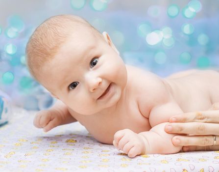 cute little girl lying on her belly on the changing table on a festive background