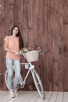 modern young woman with Bicycle and spring flowers in basket.