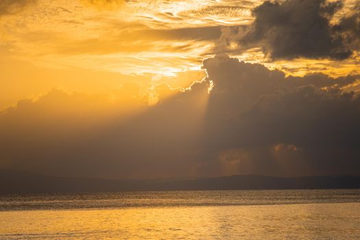 sunrise dusk shot showing a lone mangrove tree in the middle of the ocean on a beach with the sun behind it and the red gold colors of dusk shot in havelock swaraj dweep island andaman india