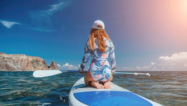 SUP Stand up paddle board. Young woman sailing on beautiful calm sea with crystal clear water. The concept of an summer holidays vacation travel, relax, active and healthy life in harmony with nature
