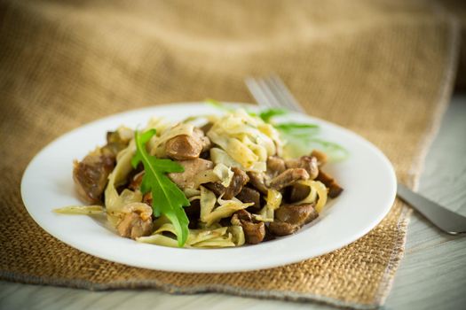 Homemade boiled noodles with meat and eggplant in a plate on a wooden table