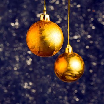 Golden Ð¡hristmas balls over blue bokeh background with copy-space