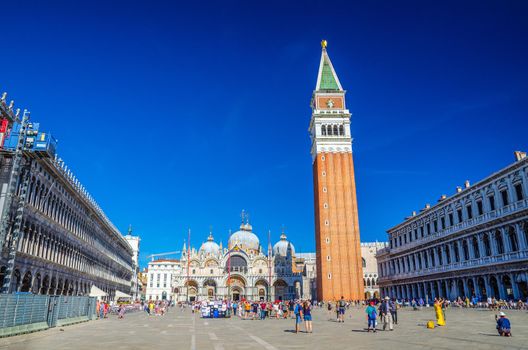 Venice, Italy, September 13, 2019: Piazza San Marco St Mark's Square, Patriarchal Cathedral Basilica of Saint Mark Archdiocese, Procuratie Vecchie and Campanile bell tower, blue sky, Veneto Region