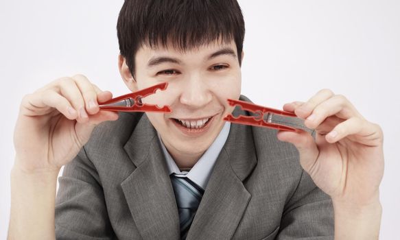 closeup.young businessman holding two clothespins,sitting behind a Desk.photo with copy space