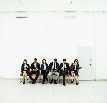 business team prepares for the beginning of the presentation sitting in the lobby of the conference hall. the photo has a empty space for your text.