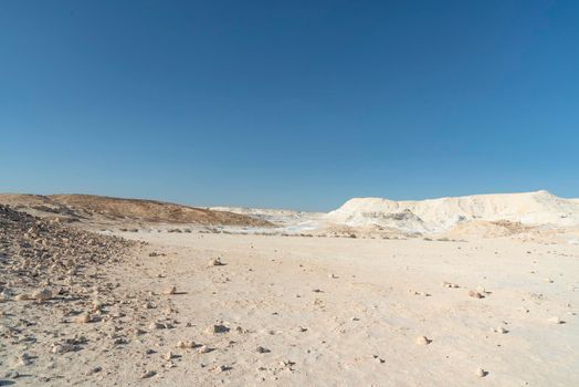 Beautiful lunar landscape. Wight and smooth hills in various shapes in a desert landscape. The whitish, rounded, winding, and smooth chalk rocks. Israel. High quality photo