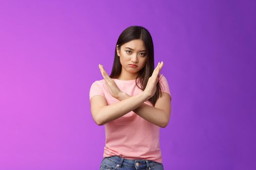 Serious-looking annoyed fed up asian girl demand stop, make arm cross chest forbidden gesture, look with scorn and disappointment, refusing terrible offer, give rejection, wanna end argument.