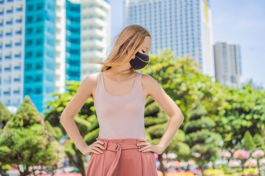 Fashionable black medical mask with filter in the city. Coronavirus 2019-ncov epidemic concept. Woman in a black medical mask. Portrait of a woman with expressive eyes during a virus or disease epidemic.