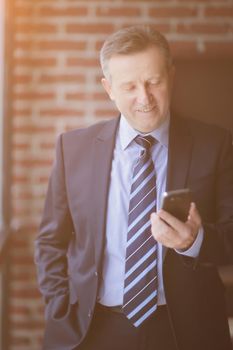 senior businessman reading text message on smartphone.people and technology