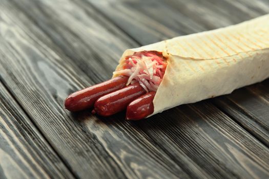 German sausages in pita bread on a dark wooden background.photo with copy space.