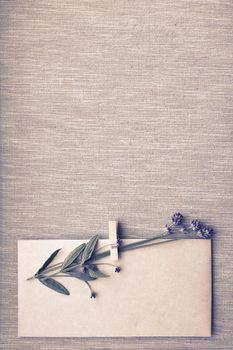 Envelope mockup and dry lavender flowers on canvas background, top view, copy space. Vintage style. A small bouquet of dry lavender on a vintage-style craft envelope. Happy Birthday, Valentine's day, wedding, Mother's Day greeting card concept. Vertical image