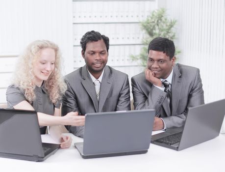 three employees sitting on the workplace in the office