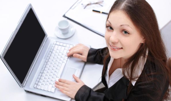 closeup.female assistant sitting at her Desk and looking at camera.