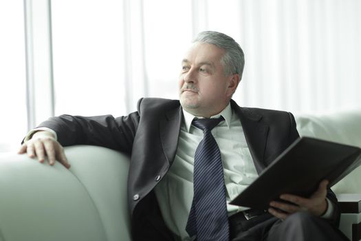 boss with clipboard sitting on the office couch.business concept.