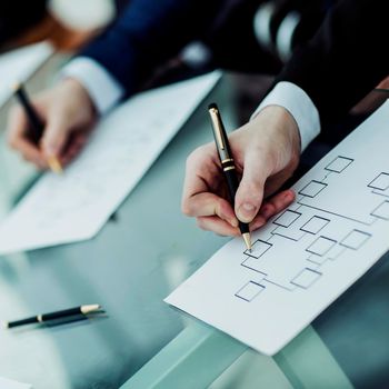 closeup: hands business team that works with financial schemes behind a Desk