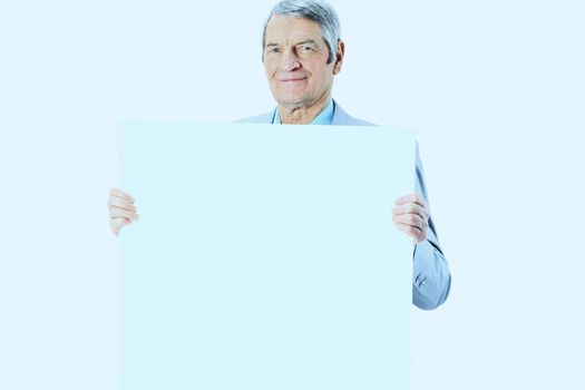 Nice businessman at the age holds white poster. Isolated on a white background.