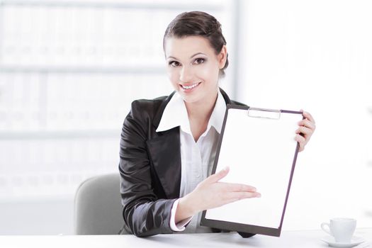 Executive business woman showing blank sheet,sitting at her Desk .photo with copy space