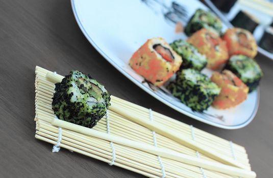 sushi rolls and chopsticks on a wooden table.Japanese cuisine