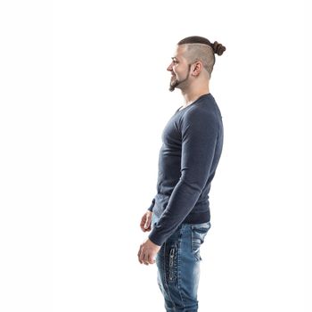 side view - the sports guy - a bodybuilder in jeans and a t-shirt on a light background . the photo has a empty space for your text