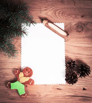 blank sheet of paper on the wooden floor with a pencil and Christmas decorations