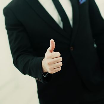 closeup of businessman making a gesture - thumbs up on white background.