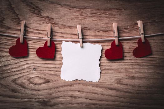 blank sheet of paper and red hearts, on a clothespin. photo with copy space