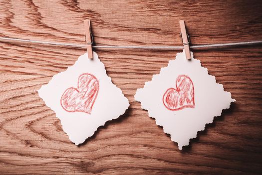 two blank sheet with painted hearts on a rope . photo with copy space