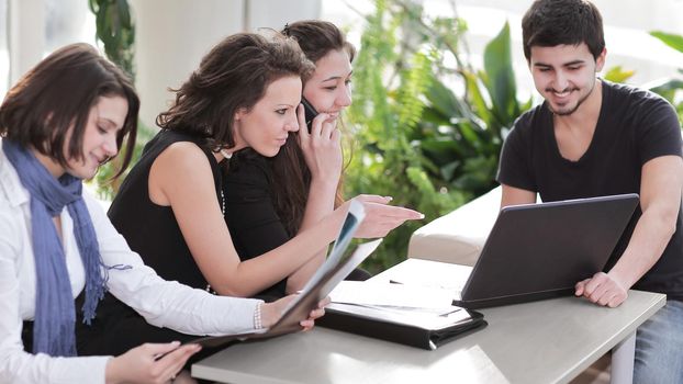 handshake colleagues sitting at the workplace.