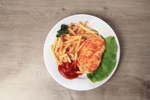 chicken in cheese and village-style potatoes with salad on plate