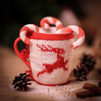 blurred image of Christmas mug and cinnamon sticks on wooden background.photo with copy space